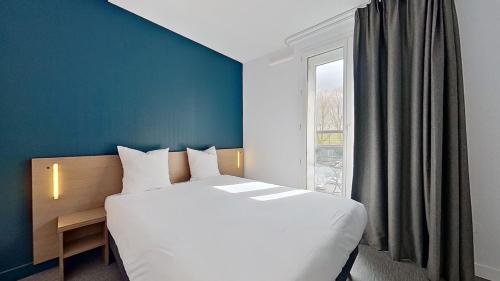 圣莫里斯City Résidence Paris Saint-Maurice的一间卧室设有一张大床和一个窗户。