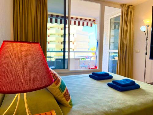 美洲海滩Borinquen Sky Apartments的一间卧室配有一张带灯和窗户的床