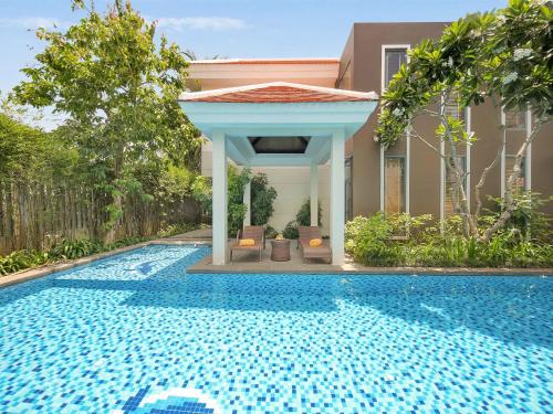 岘港Danang Ocean Resort & Spa Non Nuoc Beach Villas的房屋旁带凉亭的游泳池