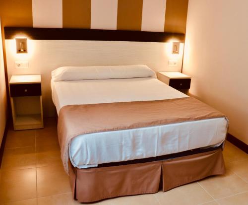 诺哈Playa Home Helgueras con acceso a Spa (AguaMarinaSpa)的一间卧室设有两张床和两个床头柜