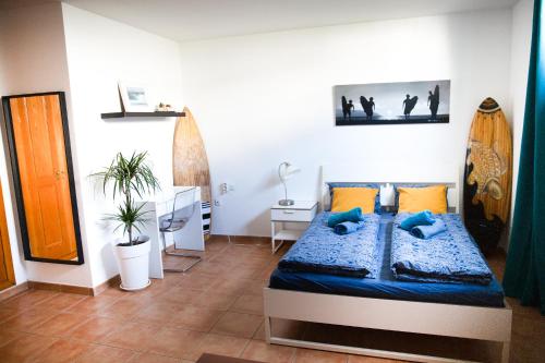 科拉雷侯SURF DREAM House的一间卧室配有一张带蓝色枕头的床