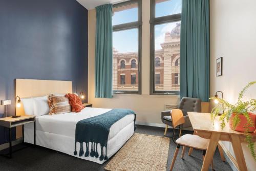 墨尔本Selina Central Melbourne的酒店客房设有一张床和一个大窗户