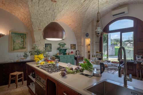 洛科罗通多阿普里勒马塞里亚酒店的厨房配有水槽和炉灶 顶部烤箱