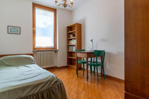 莱维科特尔梅Casa Agnese, Levico Terme - Ospitar的一间卧室配有书桌、床和窗户。