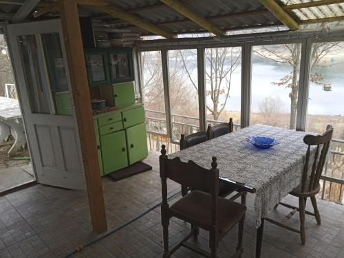 皮罗特Vikendica Vidikovac na Zavojskom jezeru的享有美景的带桌椅的用餐室