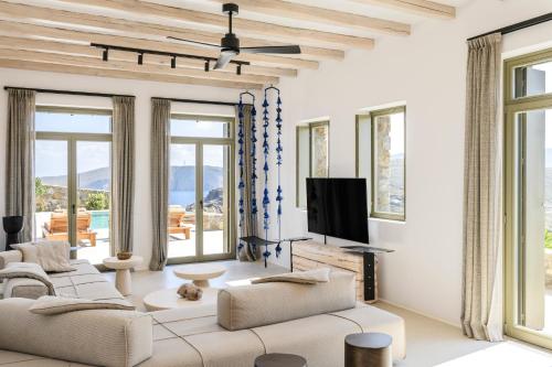 米克诺斯城Nasta Suites & Villas Intentional Living Mykonos的客厅配有白色家具和大窗户