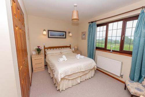 伍拉科姆Point Cottage的一间卧室设有一张床和一个窗口