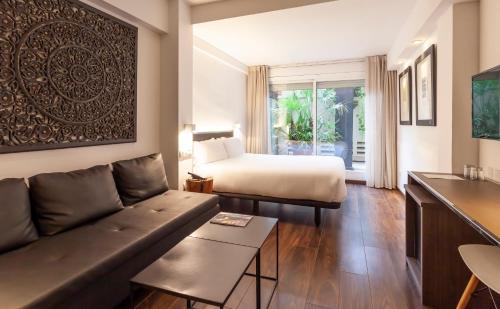 巴塞罗那德尔比酒店的客厅配有床和沙发