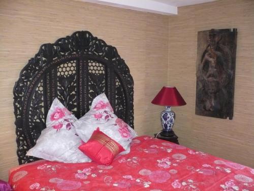 Bennecourt本尼科特勒阿弗尔德酒店的一间卧室配有黑色床、红色床单和枕头