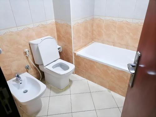 阿布扎比MBZ - Cosy Separate Room in Unique Flat的浴室配有卫生间、浴缸和水槽。