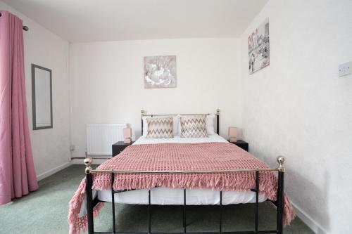 奇德尔休姆Hurley House的一间卧室配有一张带粉红色棉被的床