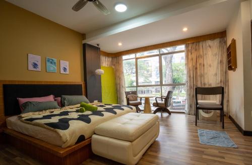 乔治市Cozy Gurney Georgetown Private Apartment Penang的一间卧室配有一张大床和一张桌子及椅子