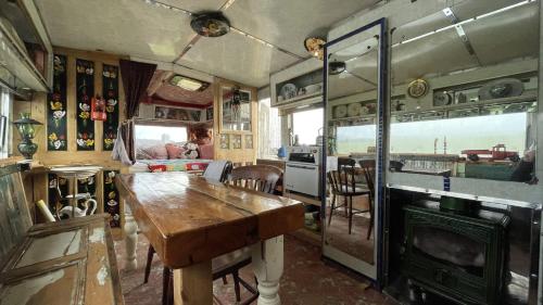 斯卡伯勒2 x Double Bed Glamping Wagon at Dalby Forest的一间旧火车室,配有桌子和厨房