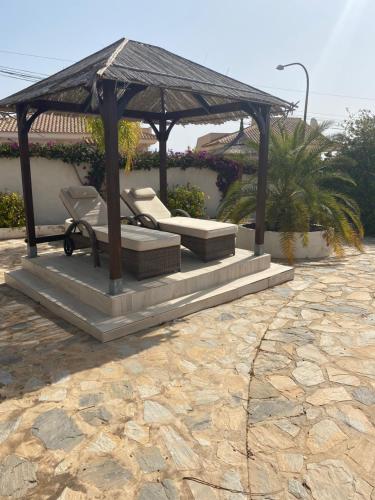博尔钮乌Casa fiesta stunning villa的凉亭配有长凳和椅子