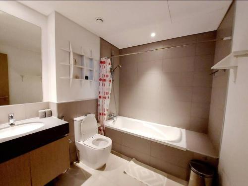 沙迦1BR Warm and comfortable APT的浴室配有盥洗盆、卫生间和浴缸。