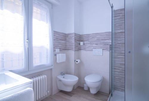 里乔内Affittacamere Ceccarini的白色的浴室设有卫生间和水槽。