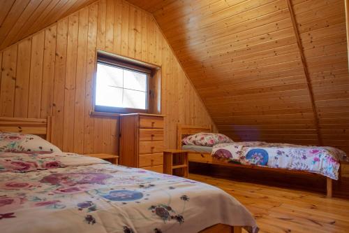 格里兹鲍Bursztynowy Zakątek的小木屋内一间卧室,配有两张床