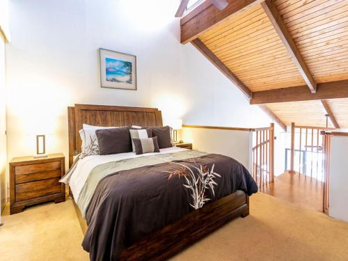 维雷亚Kamaole Sands 8-402 - 2 Bedrooms, Pool Access, Spa, Sleeps 6的一间带一张大床的卧室,位于一个拥有木制天花板的房间