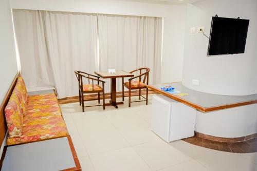 累西腓Aram Beach Boa Viagem的客厅配有桌椅和电视。