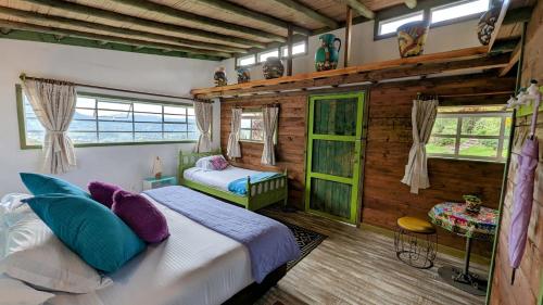塔比奥Wepa la Pepa Campestre的一间卧室设有一张床和两个窗户。