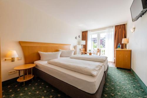 霍鲁梅尔希尔鲁切特芬恩酒店的酒店客房设有一张大床和一张桌子。