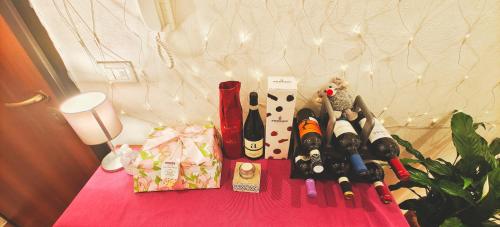 热那亚Genoa fiera b&b的一张桌子上配有带瓶装葡萄酒的粉红色桌子