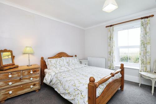 WhitwellSouthford Farm的一间卧室配有一张床、一个梳妆台和一扇窗户。