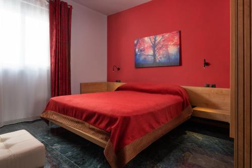 伊利索斯Fata Morgana Apartment的红色的卧室,配有一张床和红色的墙壁