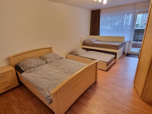 卡尔斯特Viktoria's Wohnung in Kaarst的铺有木地板的客房内的两张床