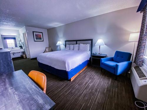 GrahamSalt Creek Lodge的酒店客房,配有一张床和一张蓝色椅子