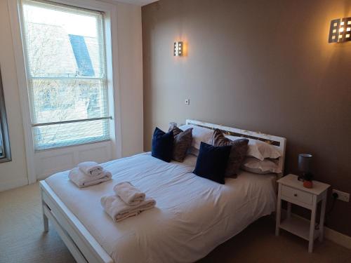 斯卡伯勒12 Easby Hall的卧室配有白色床和毛巾