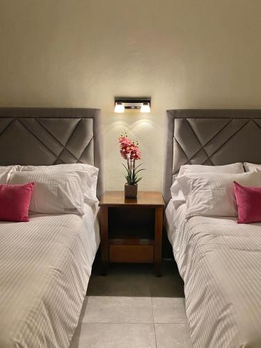 希利特拉HOTEL CASABLANCA的一间卧室配有两张床和一张鲜花桌