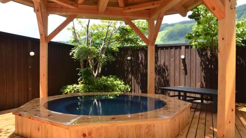 YotsuyaVilla Schole Hakuba - Vacation STAY 19519v的木甲板上的热水浴池,带凉棚