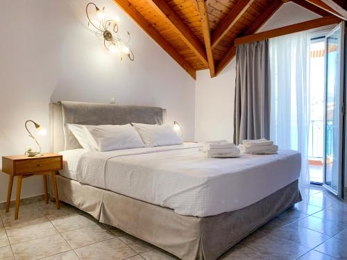 阿尔戈斯托利翁Rouchotas Apartments的卧室配有一张带吊灯的大型白色床。