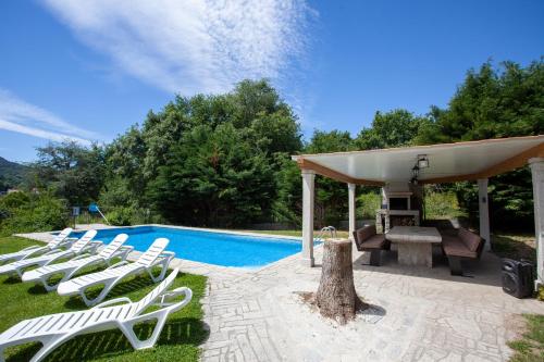 阿拉力兹Espectacular Casa con Piscina en Allariz的一组白色躺椅,位于游泳池旁
