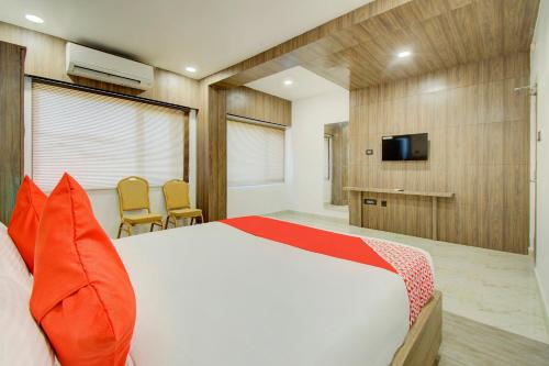 维杰亚瓦达V Hotel的一间卧室配有一张床和一台电视。