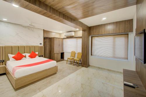 维杰亚瓦达V Hotel的一间卧室配有一张床、一张书桌和一台电视