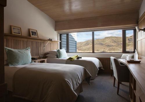 百内三塔Explora en Torres del Paine - All Inclusive的酒店客房设有两张床和大窗户。