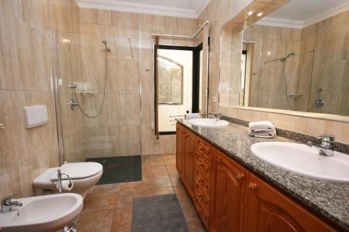 查德尔帕罗奥隆达之家别墅的一间带两个盥洗盆、淋浴和卫生间的浴室