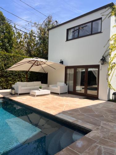 洛杉矶The Cozy Villa的一座带游泳池的房子和一座带遮阳伞的庭院