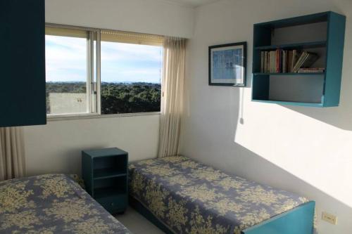埃斯特角城Torre Marfil piso 12的一间卧室设有两张床和窗户。
