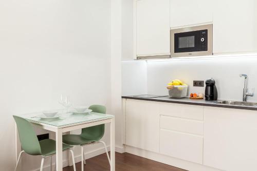 拉拉古纳El Sol,10的白色的厨房配有小桌子和椅子
