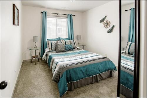 VineyardFamily-friendly Suite with HotTub MemoryBeds SmartTV的一间卧室配有一张带蓝色窗帘和镜子的床