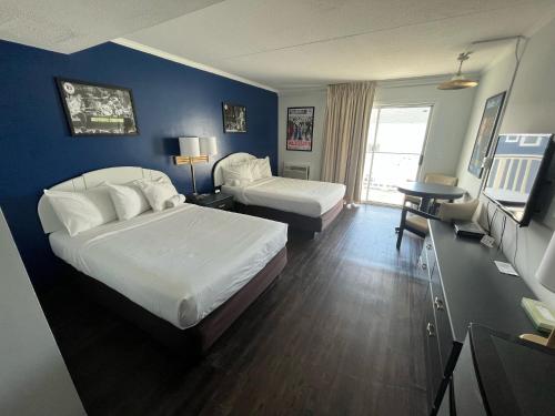 杜威海滩Hotel Dewey的酒店客房设有两张床和电视。