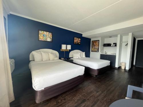杜威海滩Hotel Dewey的一间卧室设有两张床和蓝色的墙壁