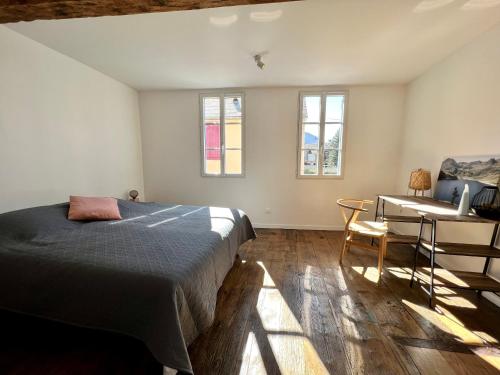 巴涅尔德比戈尔Le gîte du bonheur的卧室配有一张床、一张书桌和窗户。