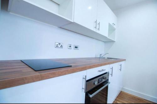 曼彻斯特Luxury Apartment near Media City的厨房配有白色橱柜和水槽