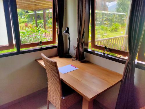 TomohonIlasan cottage.的带2扇窗户的客房内的木桌