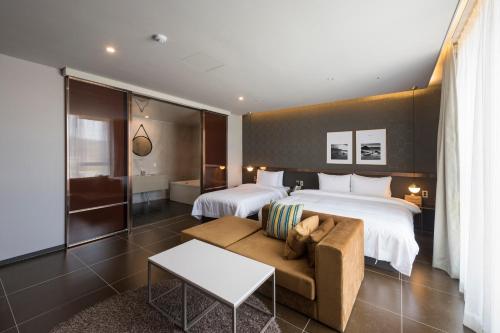 釜山Browndot hotel Guseo的酒店客房,设有两张床和一张沙发