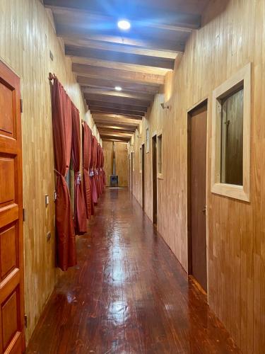 蒙特港Hostería Lenca的走廊上设有木墙,走廊上设有红色外套